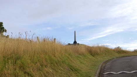 View-of-One-Tree-Hill-while-walking-towards-Obelisk-symbol,-calm-day-in-Auckland