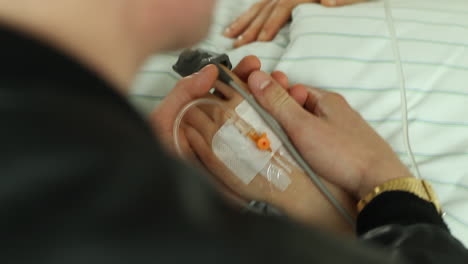 Toma-De-Mano-De-Una-Mujer-Sosteniendo-La-Mano-De-Un-Paciente-Del-Hospital.