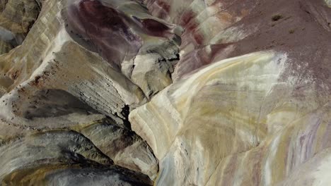 Steep-colourful-smooth-eroded-mountain-slope,-aerial-flyover-in-ARG