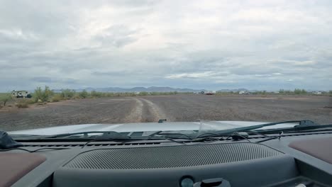 Lluvia-Y-Acampada-En-El-Desierto:-POV-Conduciendo-Por-Un-Sendero-De-Grava-A-Través-De-Grupos-De-Campistas-Dispersos-En-El-Desierto-De-Sonora-En-Un-Día-Lluvioso.