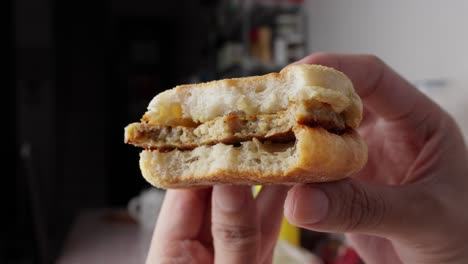 Las-Manos-Caucásicas-De-Primer-Plano-Sostienen-Una-Hamburguesa-Con-Queso-Y-Ketchup-Ya-Picada.