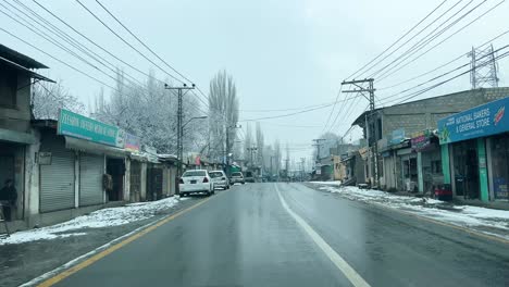 Auto-Fährt-Auf-Einer-Straße-In-Der-Stadt-Skardu-In-Einer-Schneebedeckten-Landschaft---Es-Ist-Bewölkt