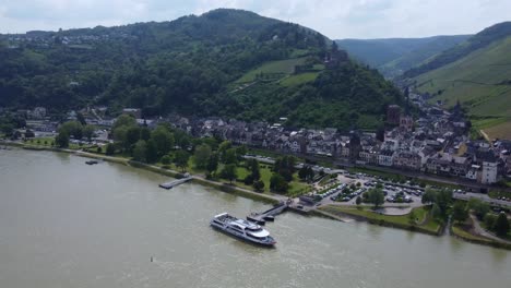 Crucero-Por-El-Río-En-El-Muelle-De-La-Ciudad-Medieval-De-Bacharach-En-Alemania,-Vista-De-Drones