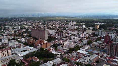 Aerial-dolly-shot-over-skyline-cityscape,-Salta-in-Argentina-mountains