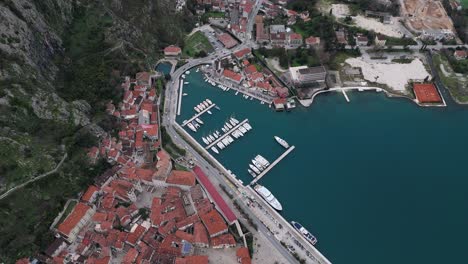 4K-Drohnenaufnahmen-Erfassen-Die-Zum-UNESCO-Weltkulturerbe-Gehörende-Altstadt-Und-Den-Hafen-Von-Kotor-In-Der-Bucht-Von-Kotor,-Montenegro