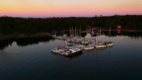 Drone-circling-the-Jussaro-guest-harbor,-summer-dusk-in-the-finnish-archipelago