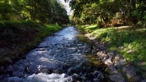 Fluss-Mit-Steinen-Und-Bäumen-Neben-Wasserfällen
