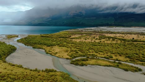 El-Río-Serpenteante-Deposita-Sedimentos-En-El-Delta-En-El-Borde-Del-Lago-Wakatipu,-Aéreo