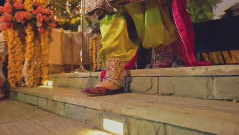 An-Indian-bride-walks-down-the-stairs-wearing-a-colorful-slipper-and-a-silver-anklet,-Close-up-view