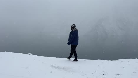Person-walking-on-a-mountain-surrounded-snow-covered-landscape-in-Skardu-City