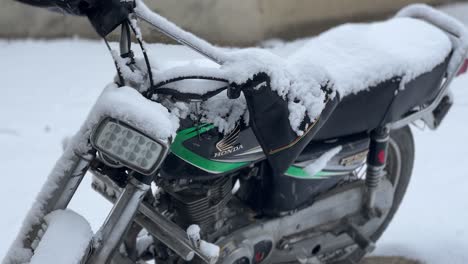 Motorbike-in-Skardu-in-pakistan-covered-with-snow-in-snowfall-standing-by-a-house