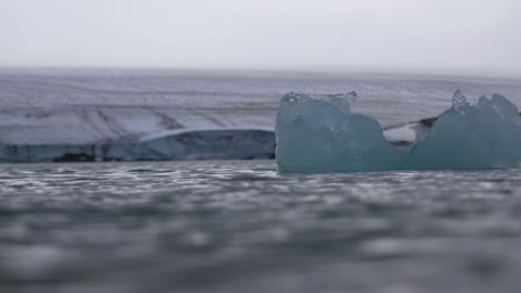 Iceberg-in-Cold-Glacial-Water-Under-Glacier,-Cinematic-Slow-Motion
