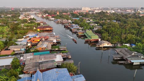 Eine-Drohnenaufnahme-Eines-Longtail-Bootes,-Das-Menschen-Auf-Einem-Wasserweg-In-Pak-Kret,-Thailand-Außerhalb-Von-Bangkok,-Transportiert