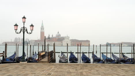 San-Giorgio-Maggiore,-gondolas-anchored-in-foreground,-Venice,-Italy