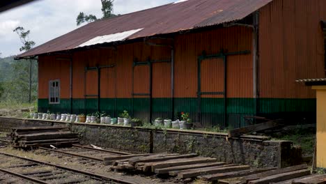 Slow-motion-landscape-of-train-maintenance-tin-storage-shed-near-platform-yard-railway-with-track-wooden-logs-timber-for-repairs-Ella-Sri-Lanka-industry