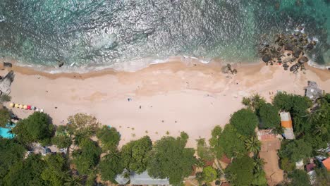 Drone-flying-over-sandy-beach-at-beautiful-tropical-resort