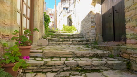 Escalera-Rústica-De-Piedra-Flanqueada-Por-Antiguas-Paredes-Y-Plantas-En-Macetas,-Típica-De-Un-Camino-Tradicional-Del-Pueblo-De-Lefkara,-Bajo-Un-Cielo-Brillante