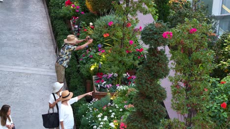 Gente-Caminando-En-El-Invernadero-De-Cristal-Con-Cúpula-De-Flores-En-Los-Jardines-Junto-A-La-Bahía,-Admirando-Varias-Flores-De-Temporada-En-Exhibición