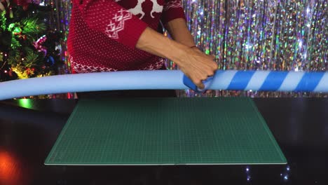 Handmade-Christmas-decorations,-wrapping-up-blue-tape-on-cany-cane