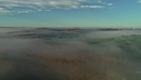 Moody-Niebla-Sobre-El-Paisaje-Con-Casas-Y-Turbinas-Eólicas