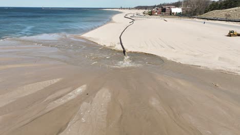 A-dredge-pipe-seen-on-lake-Michigan,-pulling-away-with-Drone