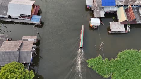 Un-Dron-Disparó-De-Arriba-Hacia-Abajo-En-Un-Bote-De-Cola-Larga-Y-En-Un-Pequeño-Vecindario-En-Las-Afueras-De-Pak-Kret-Nonthaburi,-Tailandia,-Cerca-De-Bangkok.