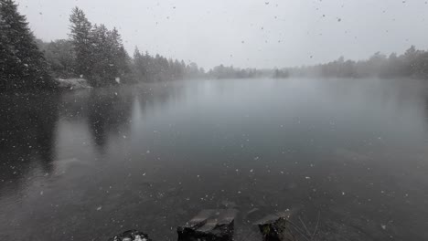 Snow-is-falling-on-Mystical-Lake-in-Austria-surrounded-by-Trees