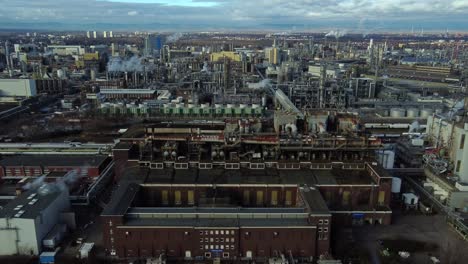 Tanker-barge-docked-at-chemical-plant-in-large-industrial-estate,-Drone-View