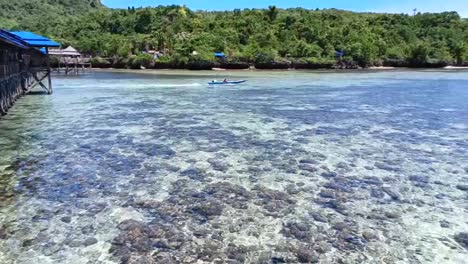 Traditional-boat-sails-in-the-sea-waters-on-Karampuang-Island,-West-Sulawesi,-Indonesia