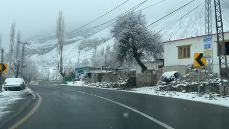 Toma-De-Punto-De-Vista-De-Un-Automóvil-Conduciendo-Por-Las-Calles-De-La-Ciudad-De-Skardy-Durante-Las-Nevadas,-Pakistán