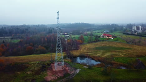 Hochspannungsleitungsnetz-Außerhalb-Des-Ländlichen-Dorfes,-Luftaufnahme-Einer-Drohne