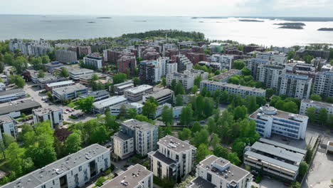 Panoramic-drone-shot-circling-the-downtown-of-Lauttasaari,-summer-day-in-Helsinki