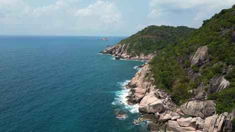 Forward-aerial-push-in-over-green-cliffs-and-ocean-on-tropical-island