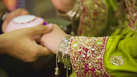 Bride-using-a-UV-light-nail-drier-to-dry-her-manicure,-Close-up-view