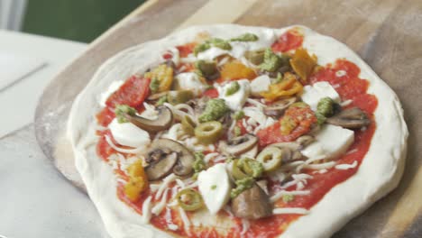 Placing-a-homemade-pizza-onto-paddle-before-baking