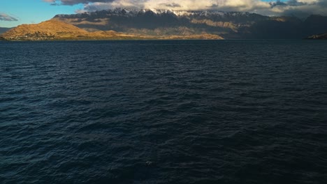 Lago-Wakatipu-Con-Montañas-Nevadas-Y-Espesas-Y-Largas-Nubes-Grises-En-La-Distancia