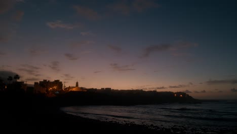 Tilt-down,-blue-hour,-slowmotion-waves-on-beeble-beach-in-Playa-La-Caleta-de-Interián-on-Tenerife,-Canary-Islands