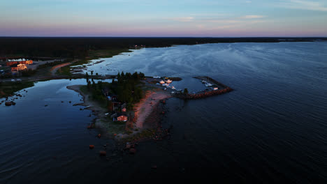 Drone-circling-the-Keskuskari-island,-moody,-summer-sunset-in-Kalajoki,-Finland