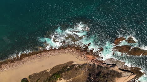 Birds-eye-drone-shot-over-waves-at-the-rocky-coast-of-Mazatlan,-in-sunny-Mexico