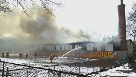 Fire-extinguishing-abandoned-school-building-by-firefighters-water-gun