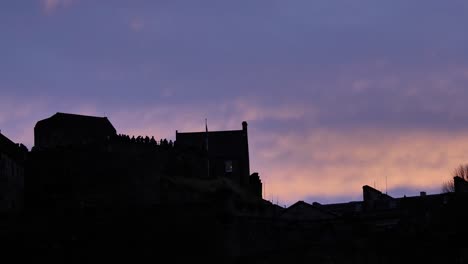 Silhouette-of-close-section-of-Edinburgh-Castle-at-sunset-on-a-winter's-night,-Scotland