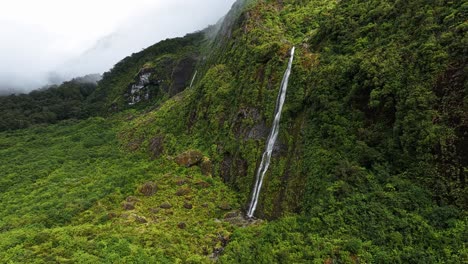 Umlaufbahn-Um-Tropischen-Wasserfall,-Der-In-Ein-Becken-Am-Fuße-Einer-Klippe-Plätschert