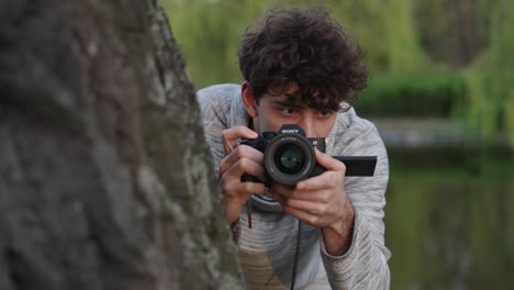 Freelance-paparazzi-hide-behind-tree-trunk-and-secretly-take-photos