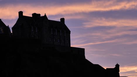 Silhouette-of-close-section-of-Edinburgh-Castle-at-sunset-on-a-winter's-night,-Scotland