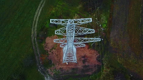 Vista-Aérea-Inclinada-Hacia-Atrás-Sobre-Una-Torre-Eléctrica-Recién-Instalada,-Sombría,-Día-De-Otoño