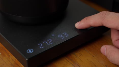 Digital-water-heater-machine,-fingers-checking-digital-temperature-number-change