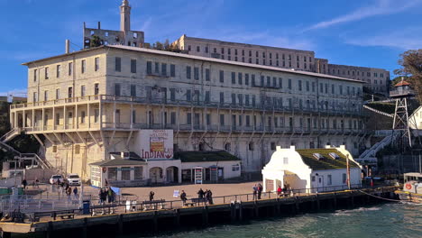 Arriving-on-Alcatraz-Island,-Prison-Buildings-View-From-Ferry-Boat-on-Sunny-Day,-California-USA