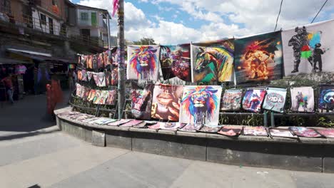 Vibrant-art-canvases-displayed-at-a-street-stall-in-Comuna-13,-Medellin