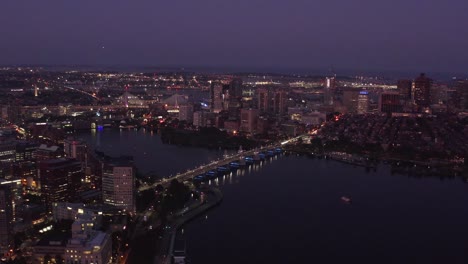 Luftaufnahme-Der-Skyline-Des-Finanzviertels-Von-Boston-Bei-Nacht-Mit-Drohnenaufnahme-Des-Charles-River-In-4K,-Massachusetts,-USA