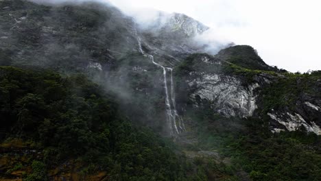 Misty-clouds-float-majestically-in-front-of-tendril-waterfalls-in-New-Zealand